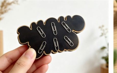 Hand holding a lettered wooden magnet